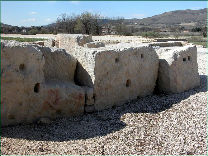 Gros bloc en calcaire dur appartenant à une corniche extérieure de l'aire à portique sud, était scéllé aux autres blocs par 4 crampons en fer, en bronze ou en plomb (négatifs visible