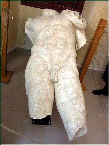 la statue d'un empereur romain, sculptée dans un marbre grec, retrouvée dans la cella du temple axial (sanctuaire)