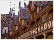 Brun, jaune, rouge et vert  la polychromie se joue des motifs géométriques des toitures de l'édifice.