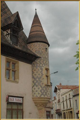 Façade avec sa poivrière d'angle, aux briques émaillées. Autrefois, relais de poste sur le  chemin royal reliant à travers le Forez, le sud de la France à la capitale du royaume